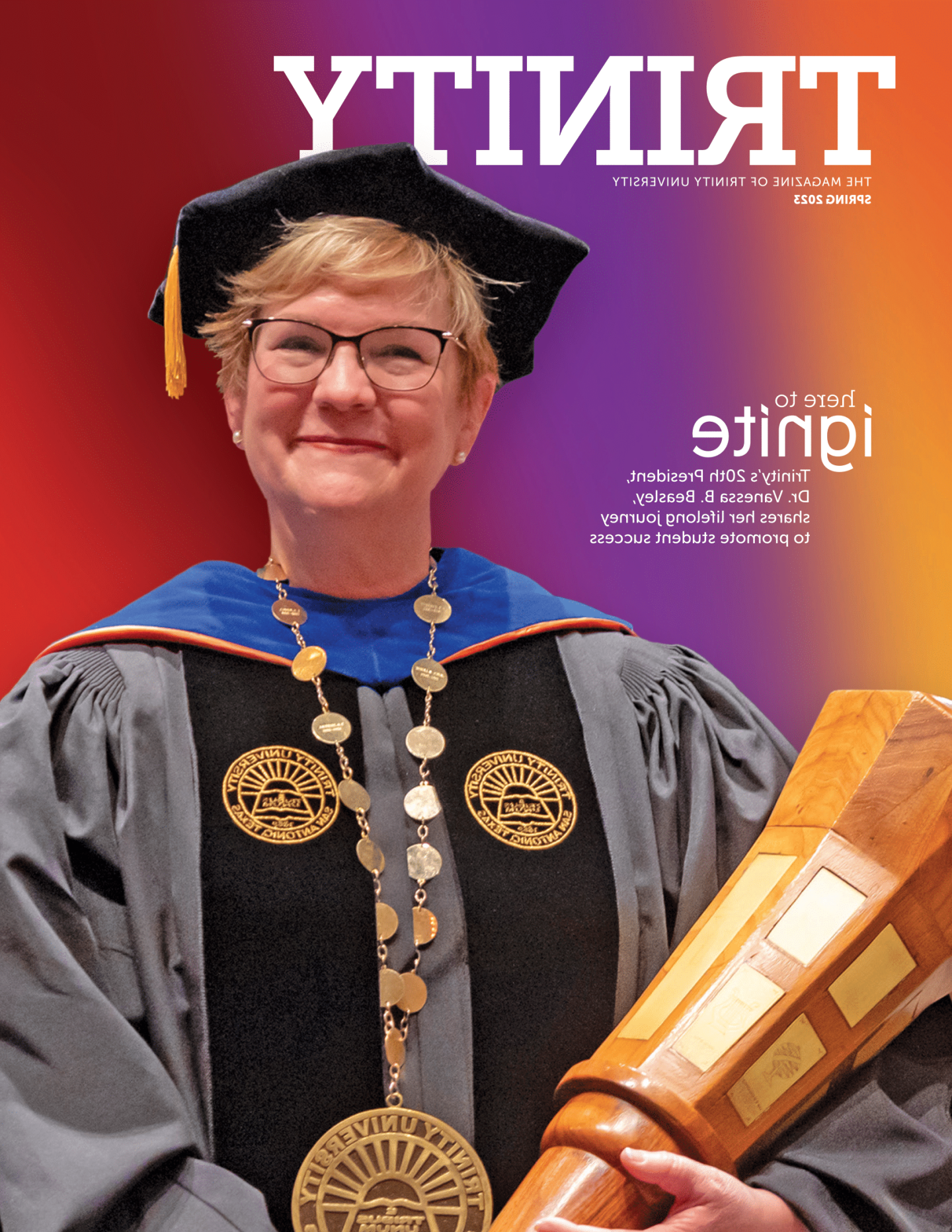 the cover of Trinity magazine Spring 2023; A portrait of Vanessa Beasley holding the presidential mace in full regalia in front of a colorful gradient